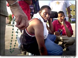 Image: People listen to radio outside Gonzalez home